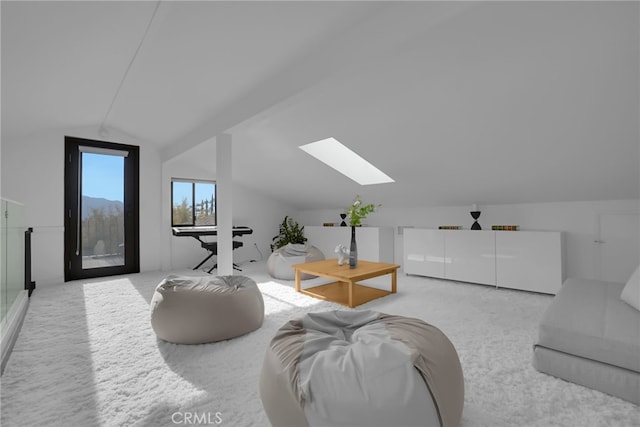 carpeted living room with vaulted ceiling with skylight