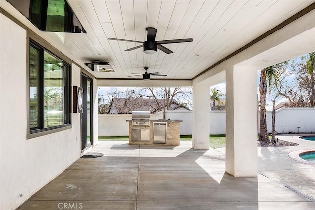 view of patio / terrace with exterior kitchen, ceiling fan, and grilling area