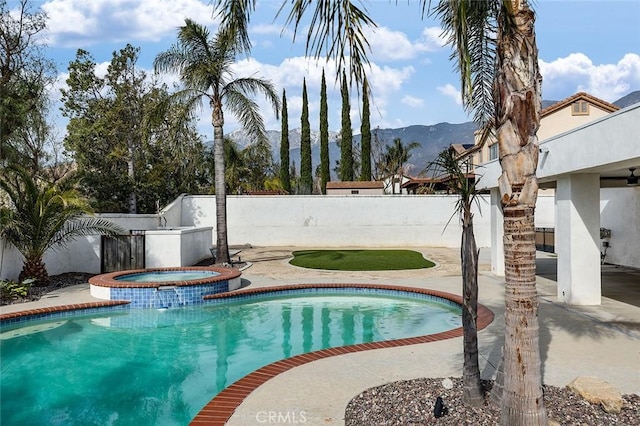 view of pool featuring a mountain view, a patio, and an in ground hot tub