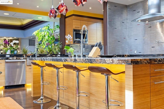 bar featuring crown molding, appliances with stainless steel finishes, backsplash, and wall chimney exhaust hood