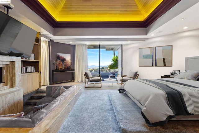 bedroom featuring crown molding, a high end fireplace, a tray ceiling, and access to exterior