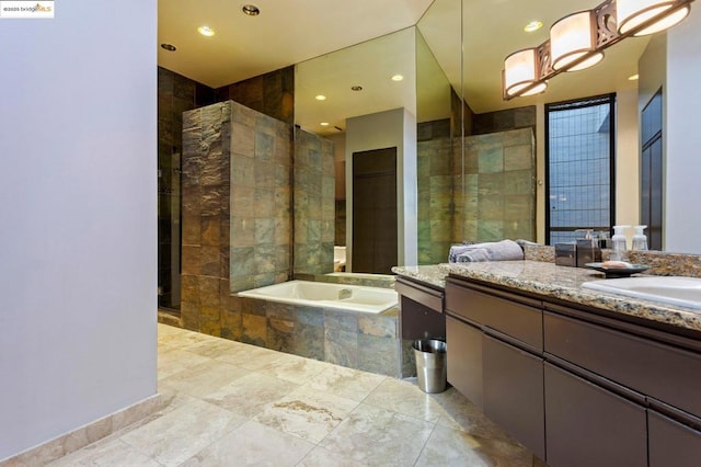 bathroom featuring a relaxing tiled tub and vanity