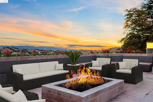 patio terrace at dusk featuring an outdoor living space with a fire pit