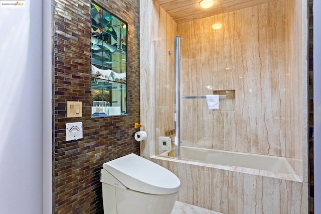 bathroom with tile walls and toilet