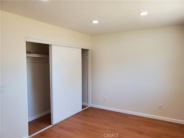 unfurnished bedroom featuring wood-type flooring and a closet