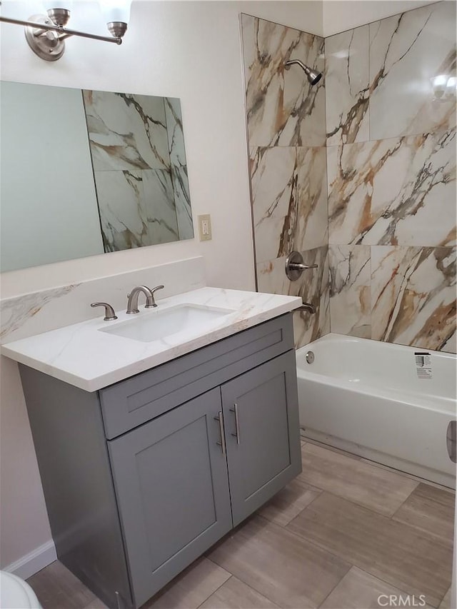 bathroom featuring tiled shower / bath and vanity