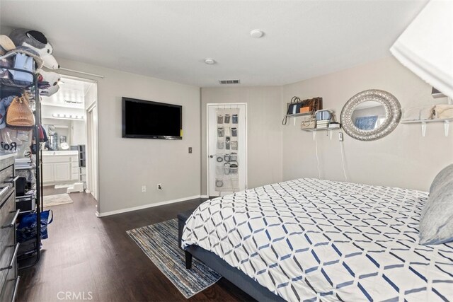 bedroom with ensuite bathroom and dark hardwood / wood-style flooring