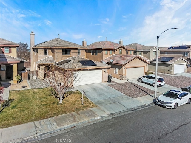 view of front of home with a garage, a front lawn, and solar panels