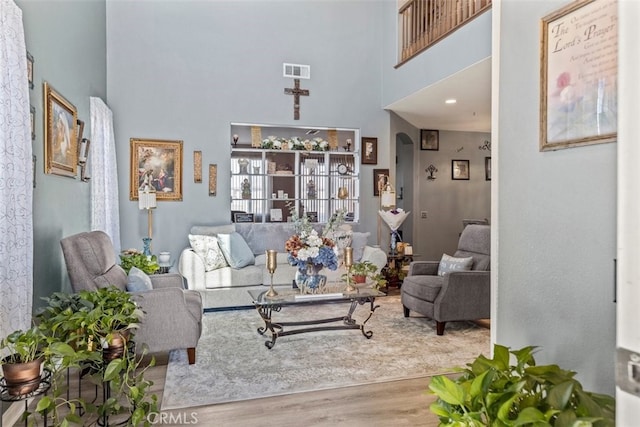 living room featuring hardwood / wood-style flooring and a high ceiling