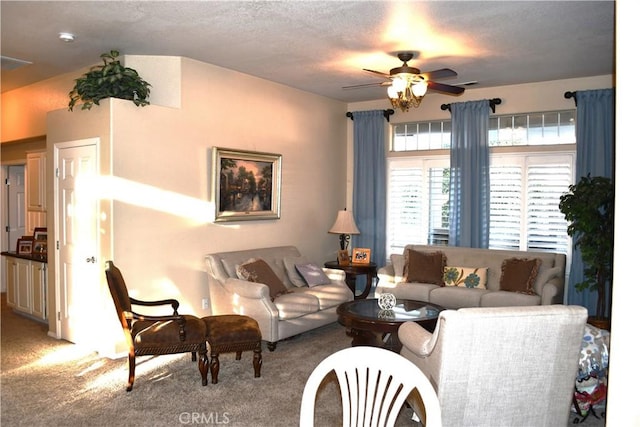 living room featuring ceiling fan, carpet floors, and a textured ceiling