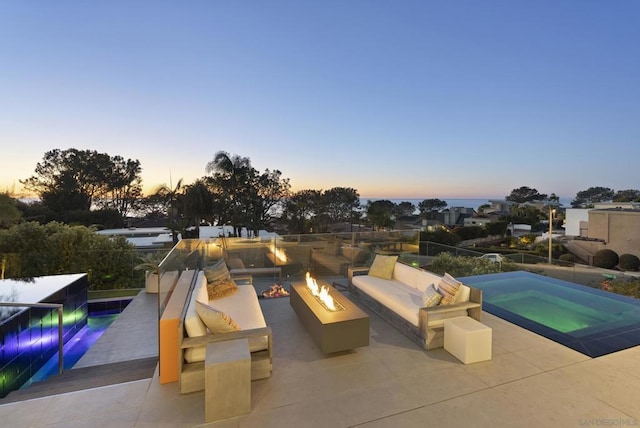 pool at dusk with a patio, an in ground hot tub, and an outdoor fire pit