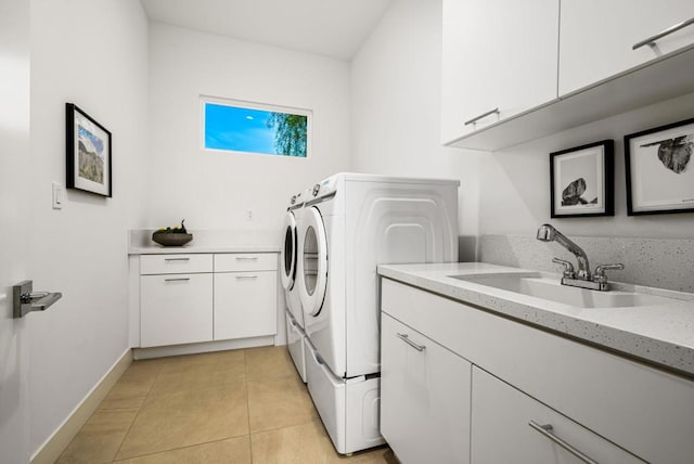 washroom with cabinets, separate washer and dryer, sink, and light tile patterned floors