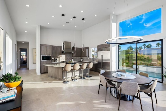 dining space featuring sink and a high ceiling