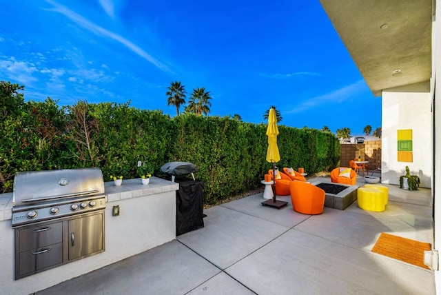 view of patio with grilling area, an outdoor kitchen, and an outdoor fire pit