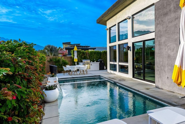 view of swimming pool with grilling area, a patio area, and exterior kitchen