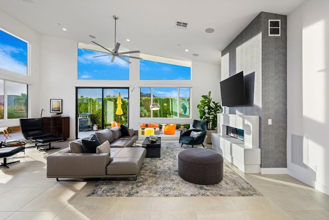 tiled living room featuring plenty of natural light, a towering ceiling, and ceiling fan