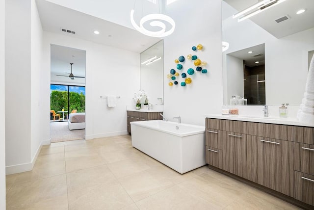 bathroom featuring vanity, tile patterned floors, shower with separate bathtub, and a high ceiling