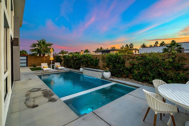 pool at dusk with a patio area