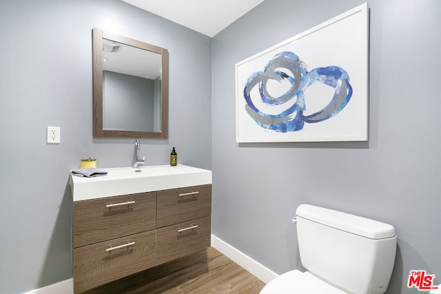 bathroom featuring hardwood / wood-style flooring, vanity, and toilet