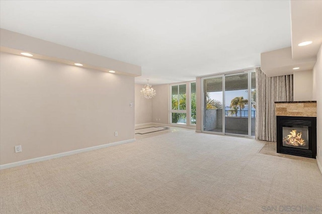 unfurnished living room featuring light carpet and a chandelier