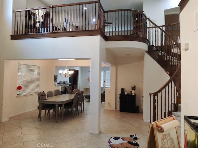 dining space with a towering ceiling, a chandelier, and light tile patterned floors