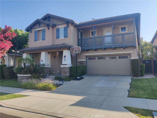 craftsman house featuring a garage, a balcony, and a front yard