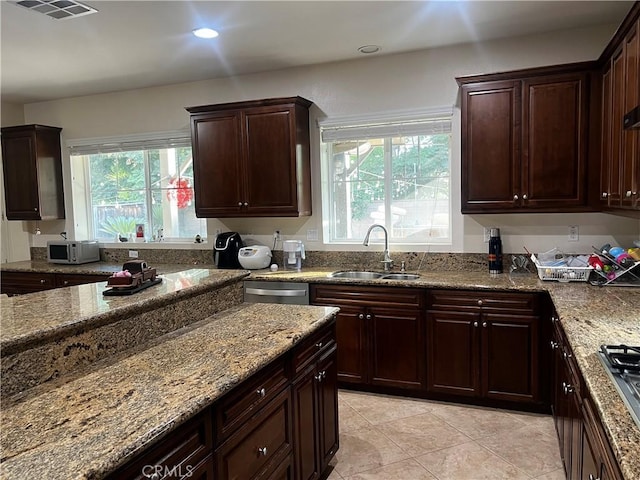 kitchen featuring sink, light tile patterned flooring, light stone countertops, and appliances with stainless steel finishes