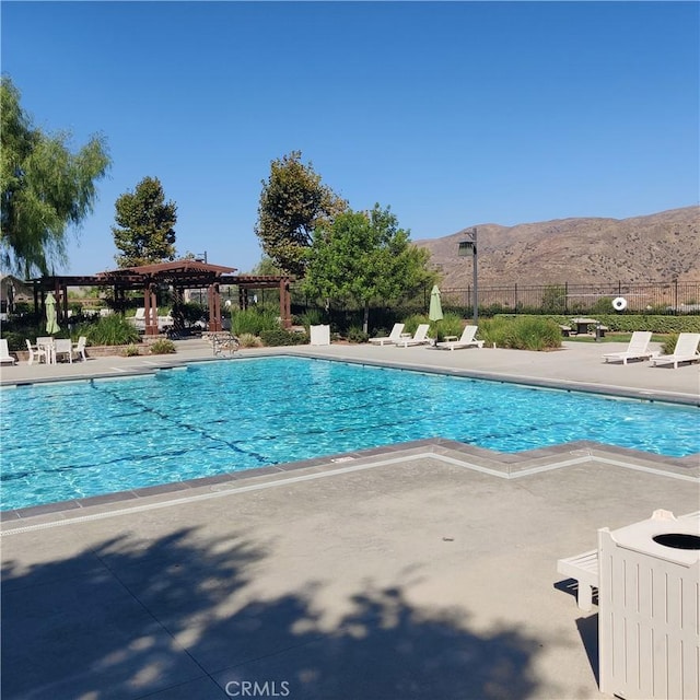 view of swimming pool with a mountain view, a pergola, and a patio area