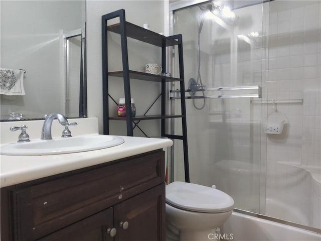 full bathroom featuring shower / bath combination with glass door, vanity, and toilet