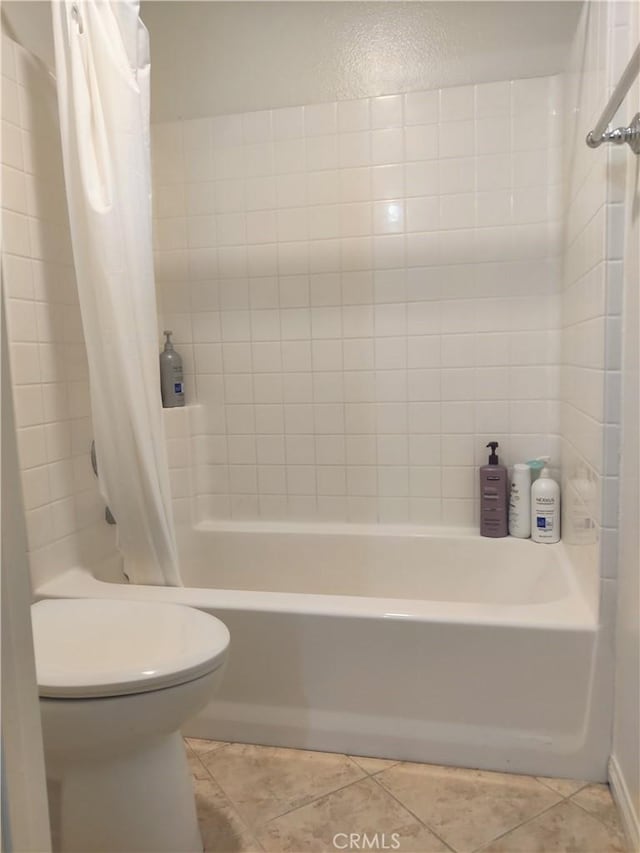 bathroom featuring tile patterned flooring, toilet, and shower / tub combo with curtain