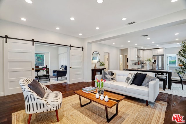 living room with a healthy amount of sunlight, a barn door, and light wood-type flooring