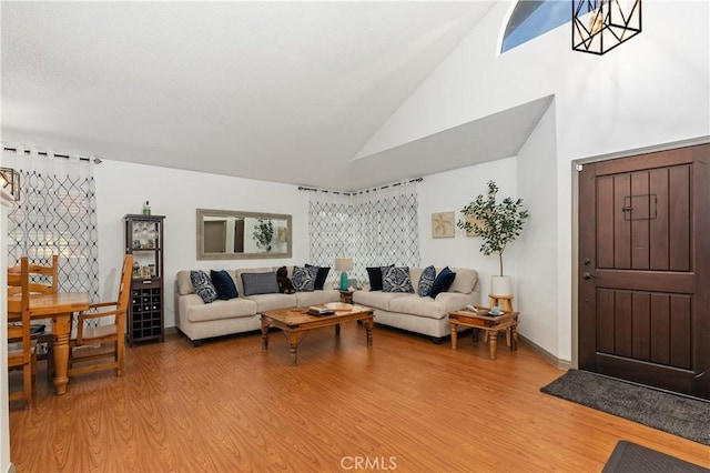 living room featuring high vaulted ceiling and hardwood / wood-style floors