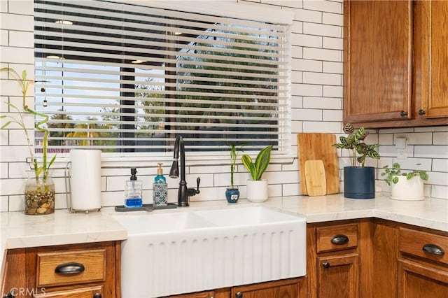 kitchen with light stone counters, sink, and decorative backsplash