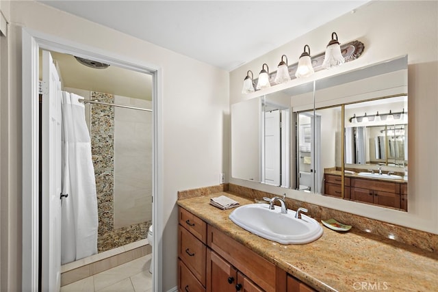 bathroom featuring tile patterned floors, vanity, toilet, and curtained shower