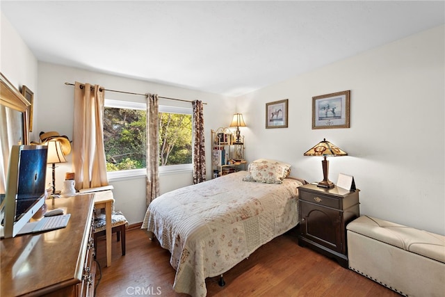 bedroom with dark hardwood / wood-style floors