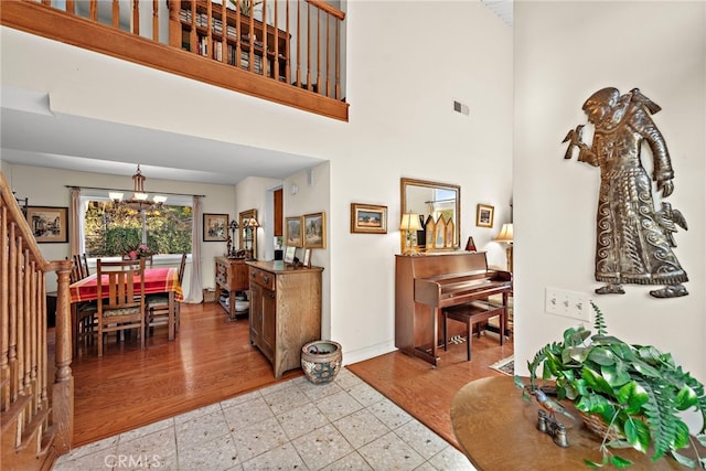 foyer with a towering ceiling, a chandelier, and light hardwood / wood-style floors