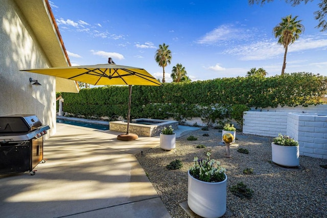 view of patio / terrace featuring a pool with hot tub and a grill