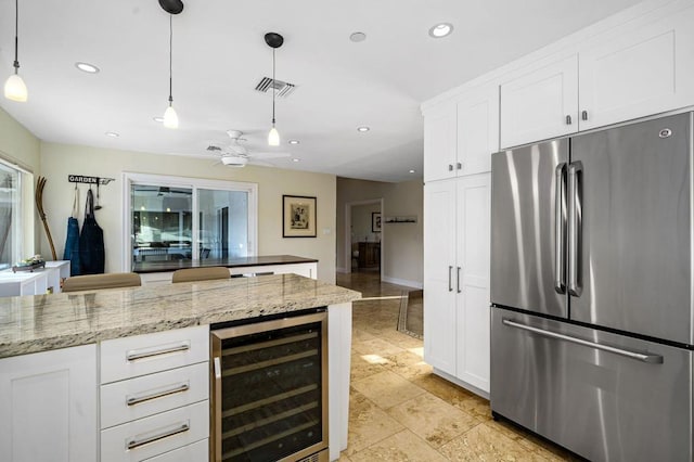 kitchen featuring white cabinets, wine cooler, stainless steel refrigerator, and decorative light fixtures