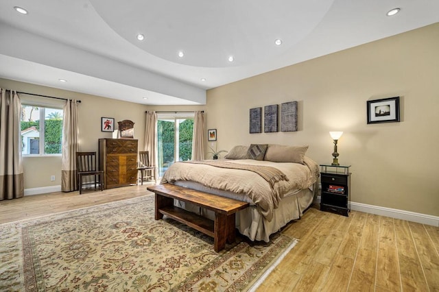 bedroom featuring multiple windows, access to outside, and light hardwood / wood-style flooring