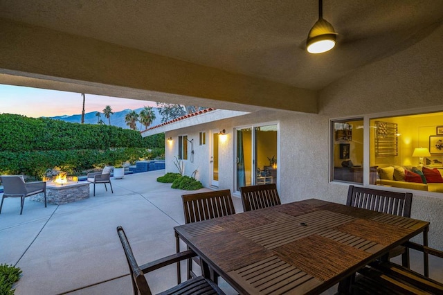 patio terrace at dusk featuring a fire pit