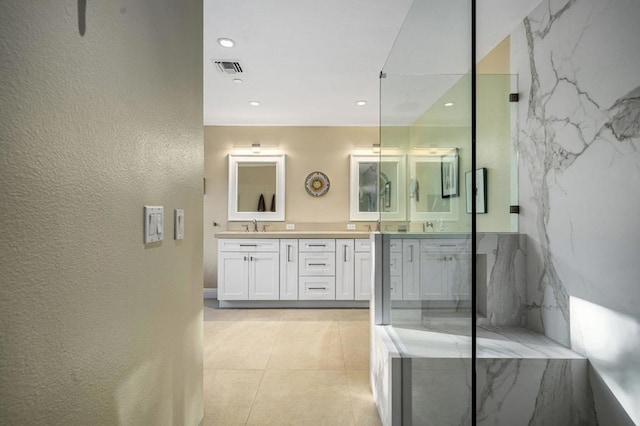 bathroom with tile patterned flooring, vanity, and walk in shower