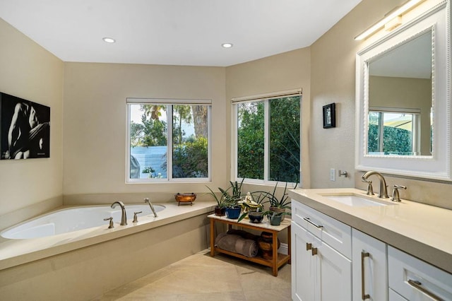 bathroom with a healthy amount of sunlight, vanity, and a tub