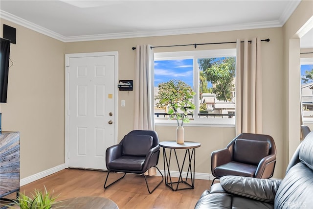 sitting room featuring ornamental molding and light hardwood / wood-style floors