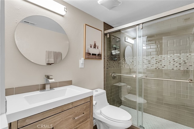 bathroom featuring vanity, a shower with door, and toilet