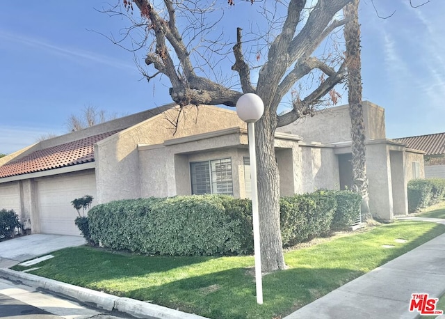 view of side of home with a garage and a lawn