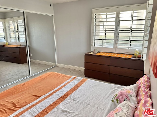 bedroom featuring light carpet and a closet