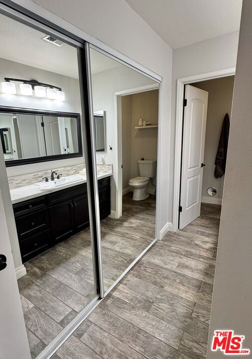 bathroom featuring hardwood / wood-style flooring, vanity, and toilet