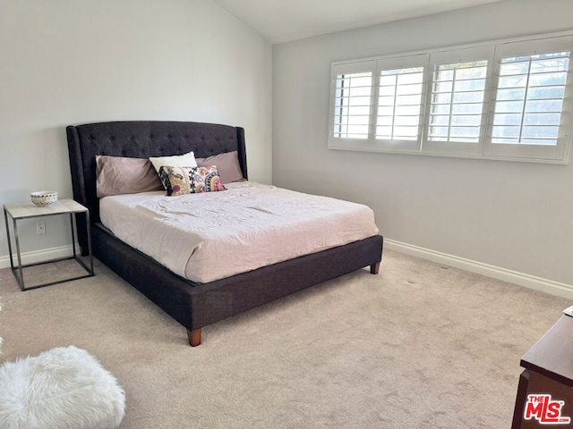 carpeted bedroom featuring lofted ceiling