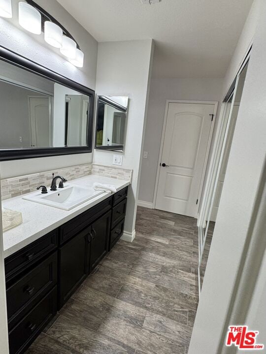 bathroom with tasteful backsplash, vanity, and hardwood / wood-style flooring