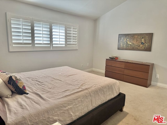 carpeted bedroom featuring lofted ceiling